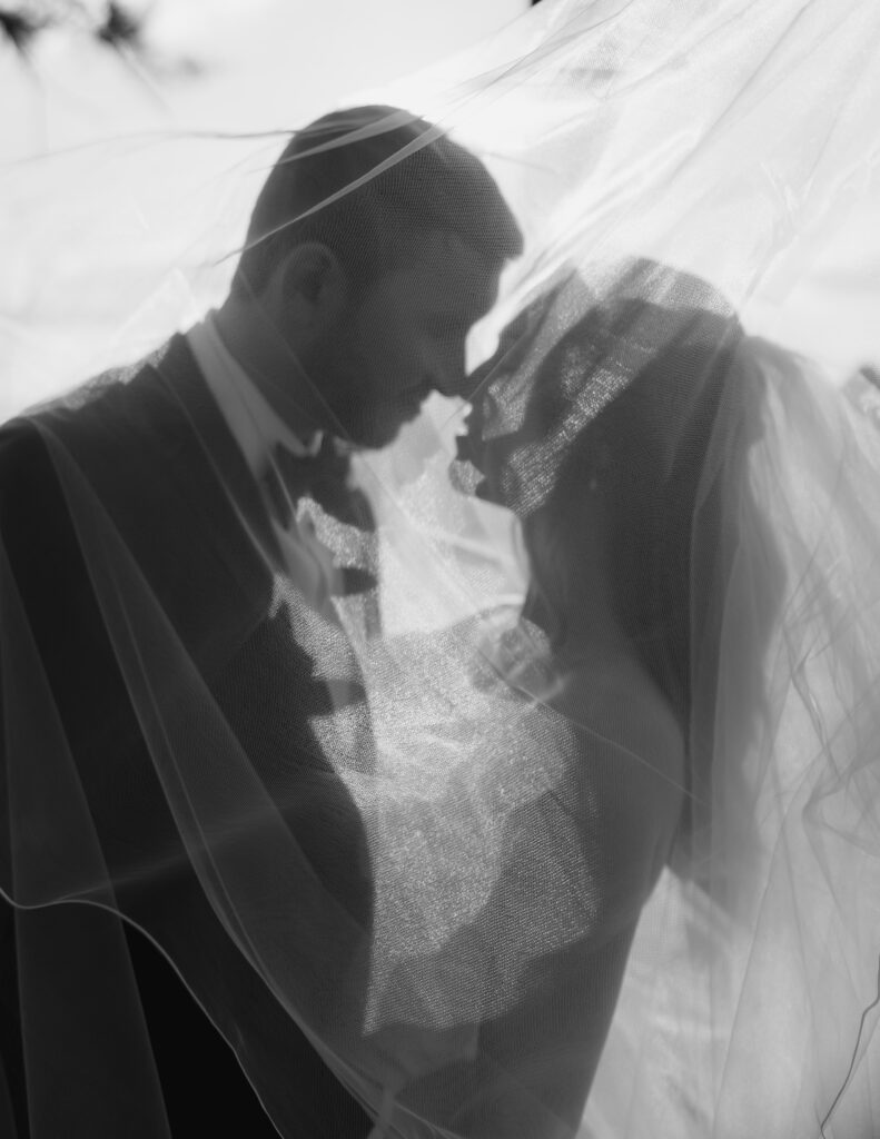 Bride and groom touching noses in romantic wedding portrait during couple portraits.