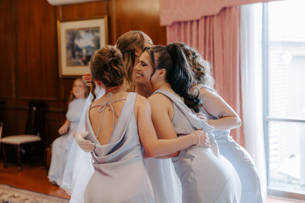 Bridesmaids and Bride hugging after getting ready.